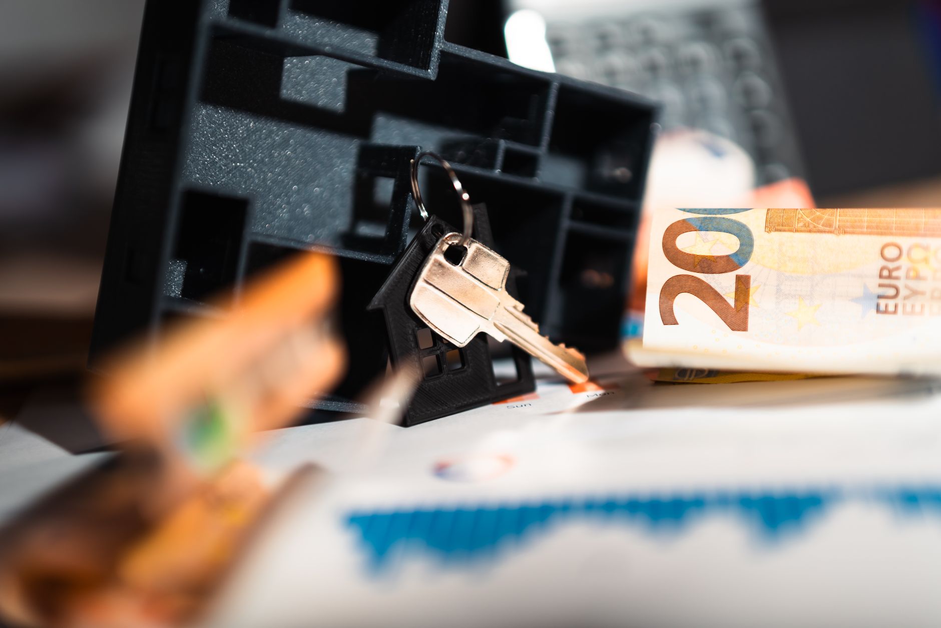 Miniatura de casa e notas de dinheiro sobre mesa representando investimento imobiliário