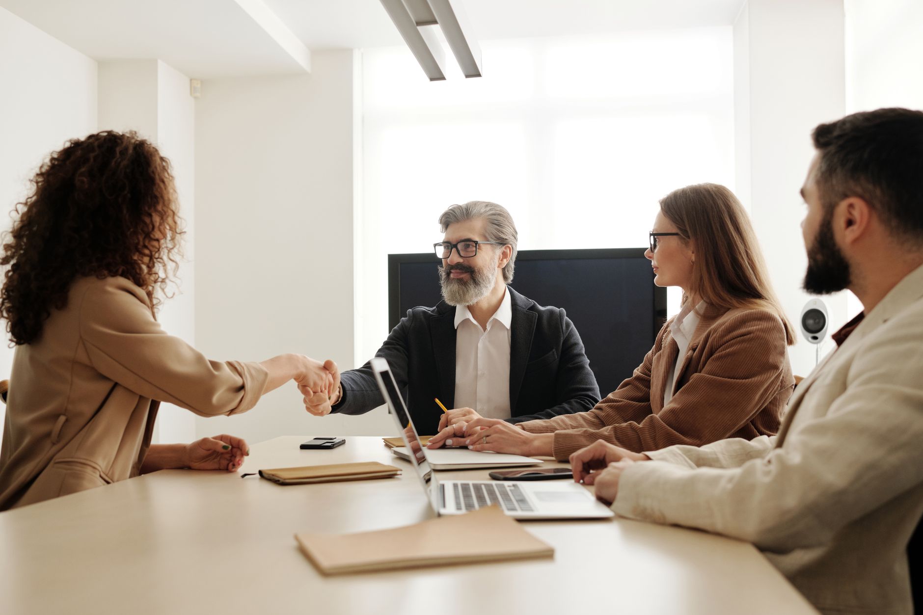 Reunião de negócios premium em sala corporativa de alto padrão simbolizando fechamento de contrato high-ticket