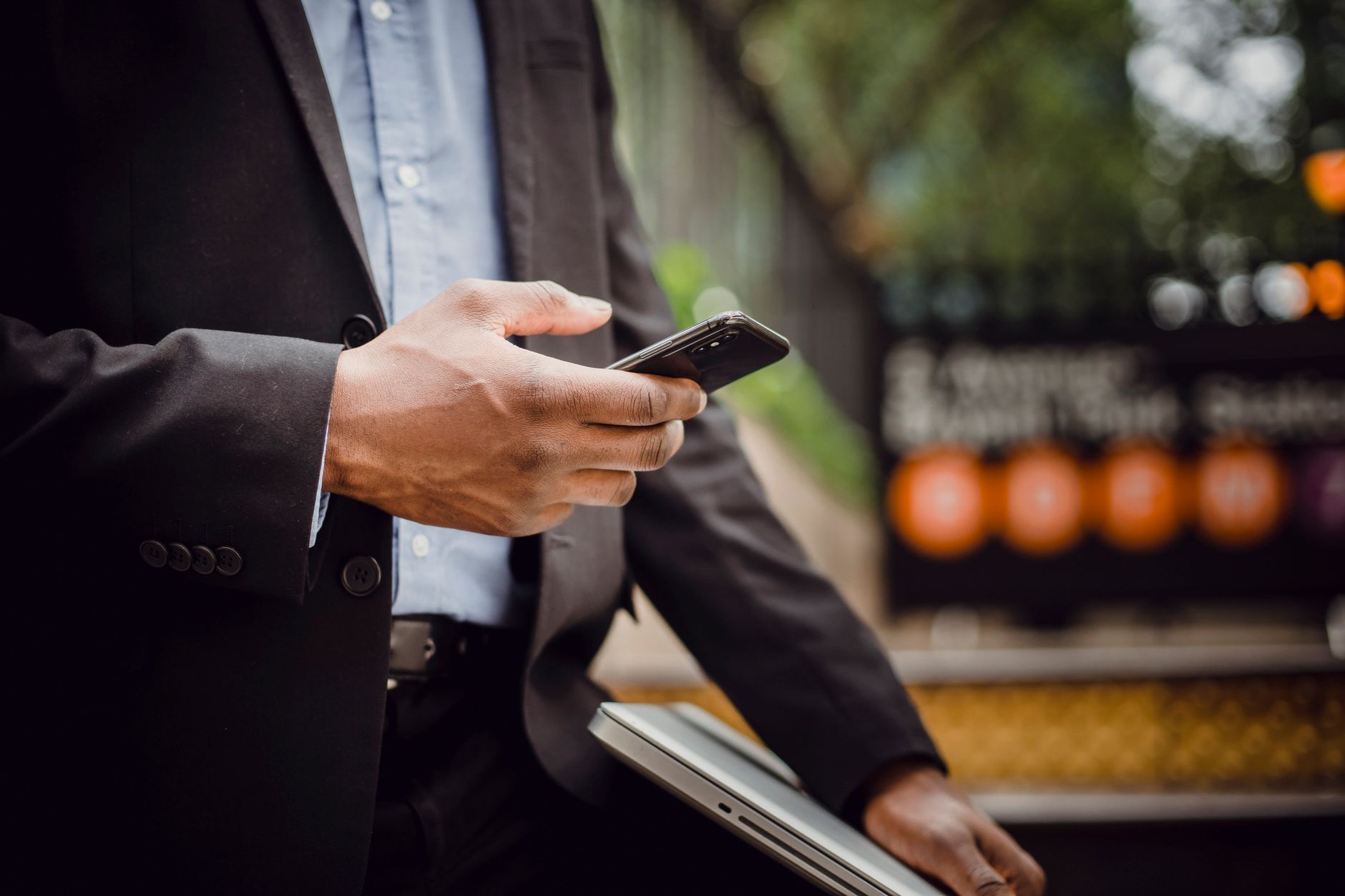 Homem de terno usando smartphone, representando negócios nas redes sociais.